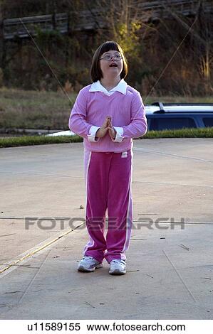 Stock Photography - Little girl with Down syndrome practicing yoga outside.. Fotosearch