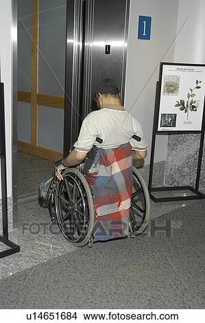 Man with a disability, entering an elevator while visiting an exhibit. View Large Photo Image Picture - Man with a disability, entering an elevator while visiting an exhibit.. Fotosearch