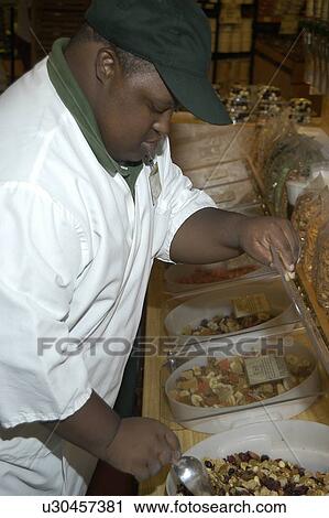 Stock Image - Man with disabilities working in a food store.. Fotosearch