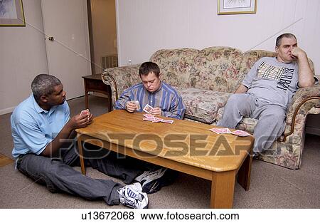 Three men with disabilities relaxing in their home -- watching TV and playing cards. View Large Photo Image Stock Photo - Three men with disabilities relaxing in their home -- watching TV and playing cards.. Fotosearch