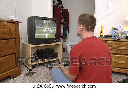 Stock Photography - Young man with disabilities playing video games in his room.. Fotosearch
