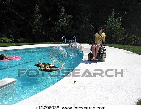 Young woman (electric wheelchair user) visits with her Mother by their accessible pool. View Large Photo Image Stock Photography - Young woman (electric wheelchair user) visits with her Mother by their accessible pool.. Fotosearch