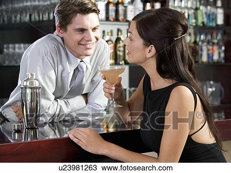 Stock Image - A barman flirting with a customer. Fotosearch