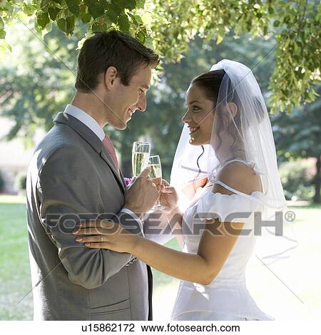 Stock Image - A bride and groom drinking champagne. Fotosearch