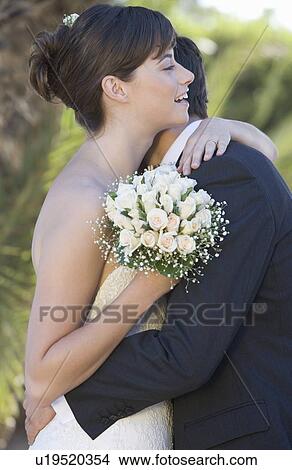 Picture - A bride and groom embracing. Fotosearch