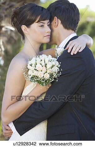 Stock Image - A bride and groom embracing. Fotosearch