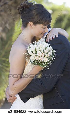 Stock Image - A bride and groom embracing. Fotosearch
