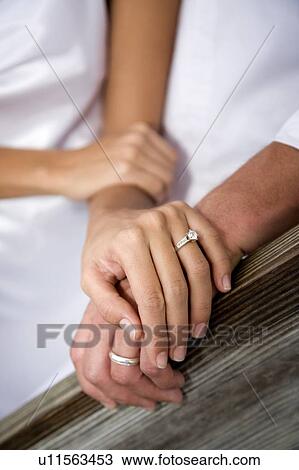 Stock Image - A bride and groom holding hands. Fotosearch