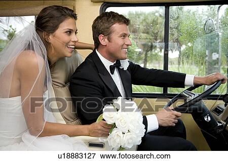 Stock Photo - A bride and groom in a car. Fotosearch
