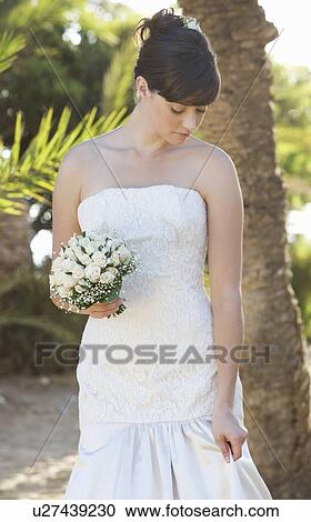Stock Image - A bride checking her dress. Fotosearch