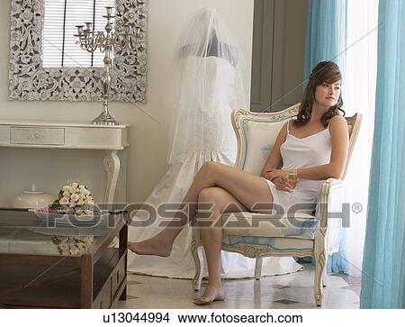Picture - A bride drinking champagne in a room. Fotosearch