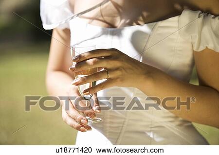 Stock Image - A bride drinking champagne. Fotosearch