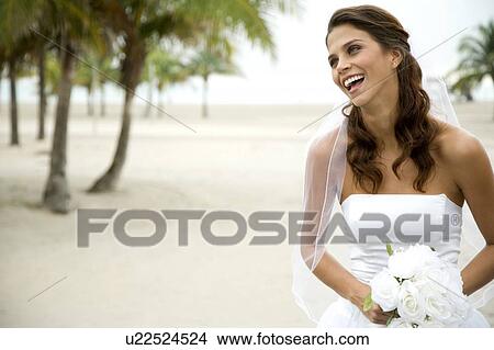 Picture - A bride standing on a beach. Fotosearch