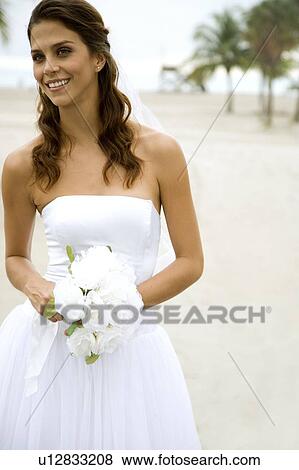 A bride standing on a beach View Large Photo Image Stock Photo - A bride standing on a beach. Fotosearch