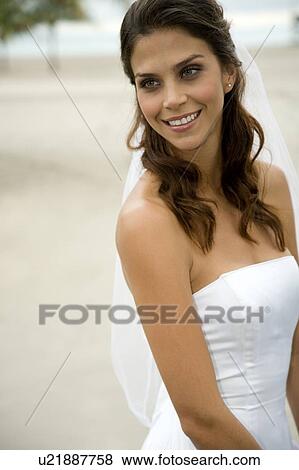 A bride standing on a beach View Large Photo Image Stock Photo - A bride standing on a beach. Fotosearch