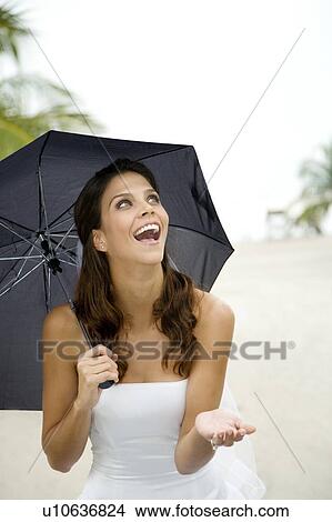 A bride standing under an umbrella View Large Photo Image Picture - A bride standing under an umbrella. Fotosearch