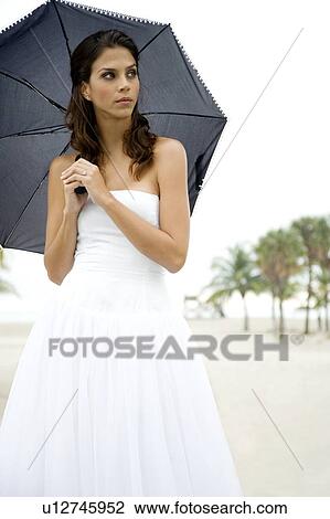 A bride standing under an umbrella View Large Photo Image Stock Image - A bride standing under an umbrella. Fotosearch