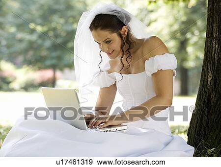 A bride using a laptop View Large Photo Image Stock Photo - A bride using a laptop. Fotosearch