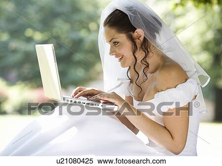 Stock Photography - A bride using a laptop. Fotosearch