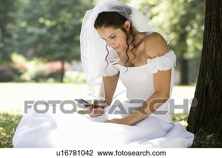 A bride using a mobile phone View Large Photo Image Stock Image - A bride using a mobile phone. Fotosearch
