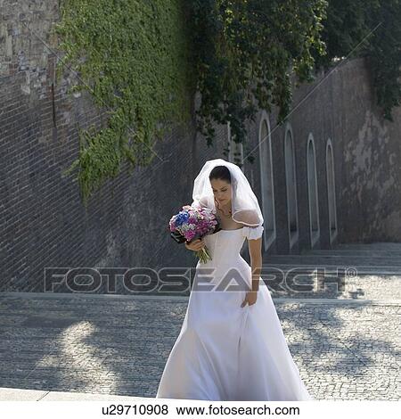 A bride walking in a cobbled street View Large Photo Image Stock Photo - A bride walking in a cobbled street. Fotosearch