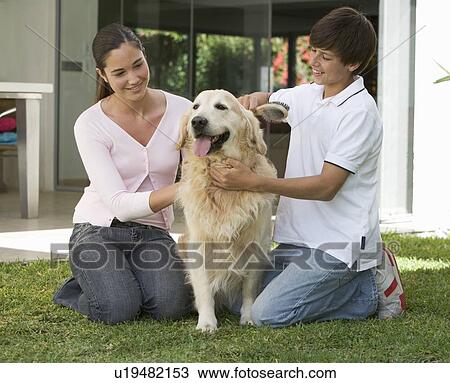Stock Image - A brother and sister with their dog in the garden. Fotosearch