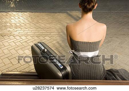 Picture - A business woman sitting on a bench. Fotosearch