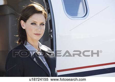 A business woman standing by a plane View Large Photo Image Stock Photography - A business woman standing by a plane. Fotosearch