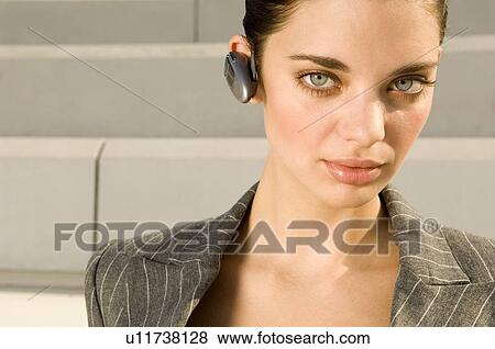 A business woman wearing a bluetooth earpiece View Large Photo Image Stock Photo - A business woman wearing a bluetooth earpiece. Fotosearch