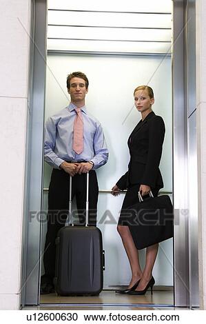 Stock Image - A businessman and woman with suitcases. Fotosearch