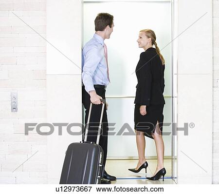 Stock Photo - A businessman and woman with suitcases. Fotosearch