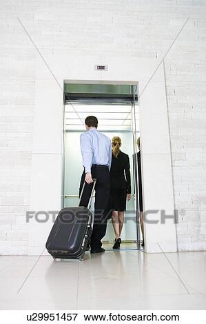 Stock Photo - A businessman and woman with suitcases. Fotosearch