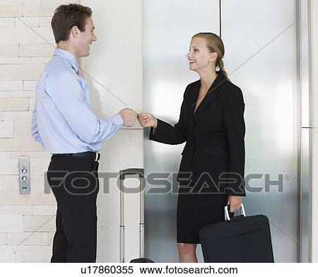 Stock Photography - A businessman and woman with suitcases. Fotosearch