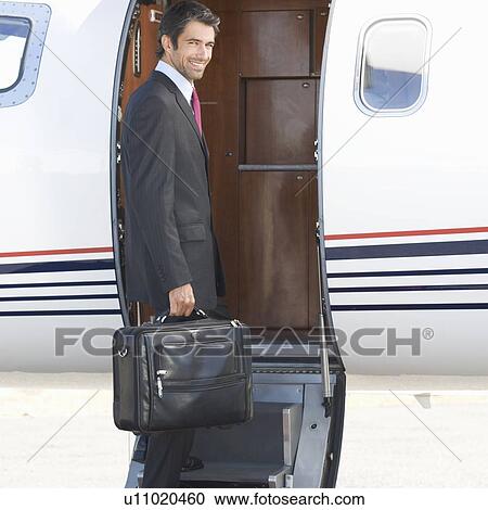 A businessman boarding a plane View Large Photo Image Stock Image - A businessman boarding a plane. Fotosearch