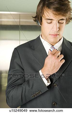A businessman checking his tie View Large Photo Image Stock Photo - A businessman checking his tie. Fotosearch