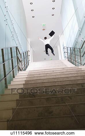 Stock Photograph - A businessman jumping at the top of stairs. Fotosearch