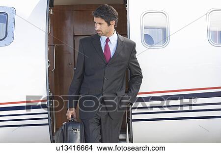 A businessman leaving a plane View Large Photo Image Picture - A businessman leaving a plane. Fotosearch