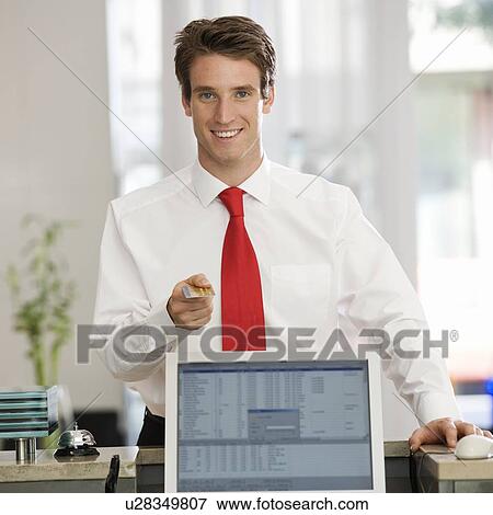 Stock Photo - A businessman paying with a credit card. Fotosearch