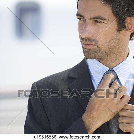 A businessman standing by a plane View Large Photo Image Stock Photograph - A businessman standing by a plane. Fotosearch