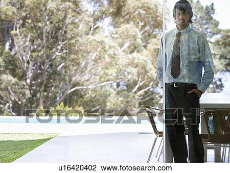 Stock Image - A businessman standing in a garden. Fotosearch