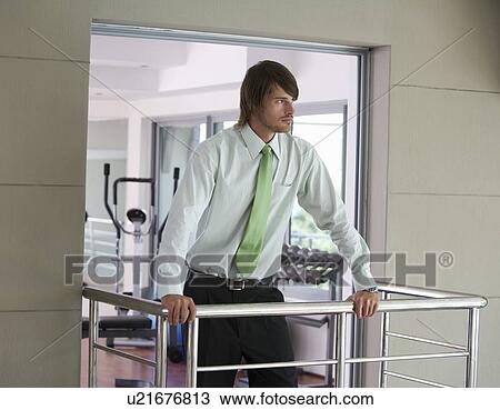Stock Image - A businessman standing in a gym. Fotosearch