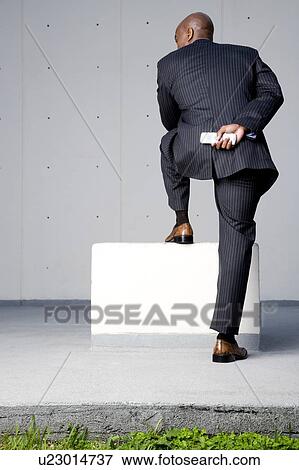A businessman standing on a block View Large Photo Image Stock Photo - A businessman standing on a block. Fotosearch