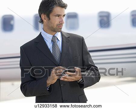 A businessman talking on a mobile phone View Large Photo Image Stock Photo - A businessman talking on a mobile phone. Fotosearch