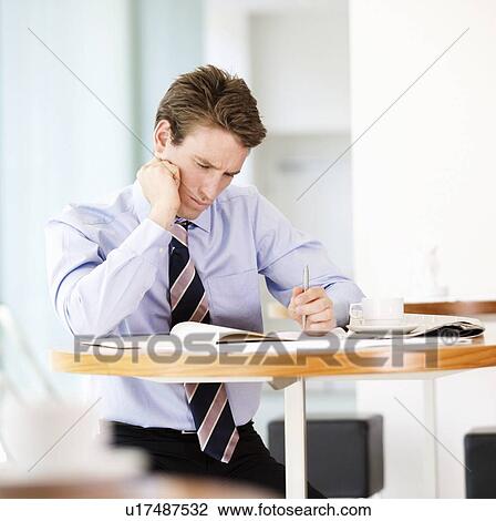 Stock Image - A businessman waiting in a hotel lobby. Fotosearch