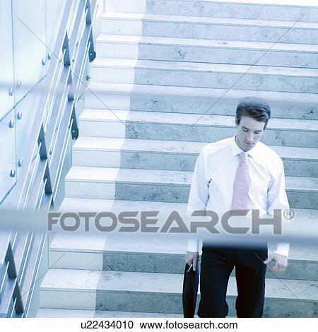 Stock Image - A businessman walking down stairs. Fotosearch