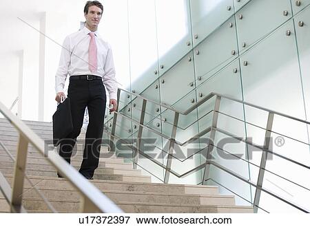 Stock Photo - A businessman walking down stairs. Fotosearch