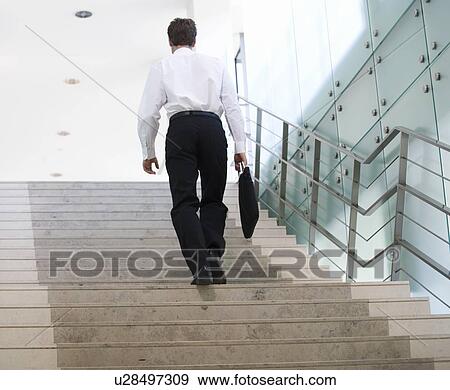 A businessman walking up stairs View Large Photo Image Stock Photo - A businessman walking up stairs. Fotosearch