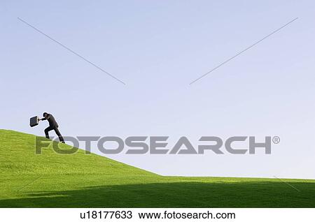 A businessman with a suitcase walking uphill View Large Photo Image Stock Image - A businessman with a suitcase walking uphill. Fotosearch