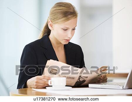 Stock Image - A businesswoman reading a paper. Fotosearch