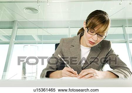 A businesswoman sitting at a table View Large Photo Image Stock Photography - A businesswoman sitting at a table. Fotosearch